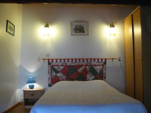 ein Schlafzimmer mit einem Bett mit zwei Lichtern an der Wand in der Unterkunft Les rosiers in Chaffaut-Lagremuse