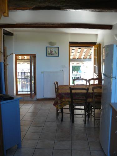 une cuisine et une salle à manger avec une table et des chaises dans l'établissement Les rosiers, à Chaffaut-Lagremuse