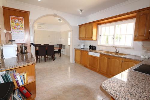 eine Küche mit Holzschränken und ein Esszimmer in der Unterkunft Villa Nataliza 172- Clever Details in Vilamoura