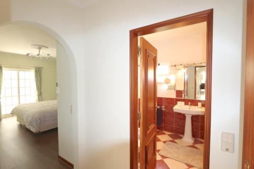 Schlafzimmer mit einem Bett, einem Waschbecken und einem Spiegel in der Unterkunft Villa Nataliza 172- Clever Details in Vilamoura