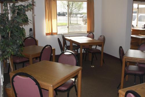 a dining room with tables and chairs and a window at Dakota Inn in Huron