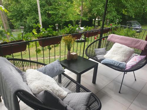 une terrasse avec 2 chaises et une table avec un canapé dans l'établissement Agape Glamping, à Velika Remeta