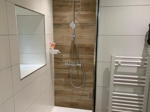 La salle de bains est pourvue d'une douche avec une porte en verre. dans l'établissement Chambres d'hôtes Logis Charrier Le Petit Bignon, aux Épesses