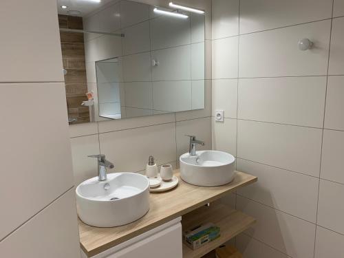 a bathroom with two sinks and a mirror at Chambres d'hôtes Logis Charrier Le Petit Bignon in Les Épesses