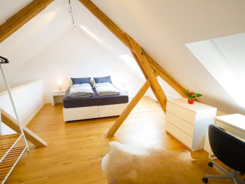 een slaapkamer op zolder met een bed en een bureau bij Lutterbach in Monschau