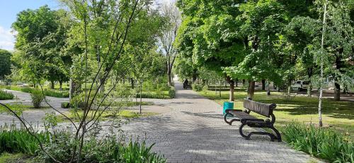 a park bench sitting on a path in a park at Квартира біля центральної площі Перспективна 22 in Oleksandriya