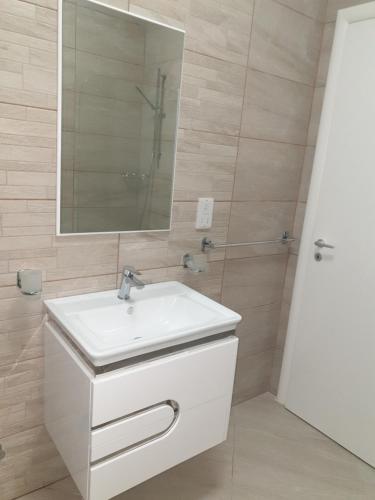 uma casa de banho com um lavatório branco e um espelho. em The City Gem Victoria em Victoria