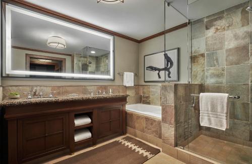 a bathroom with a tub, sink and mirror at Four Seasons Resort Whistler in Whistler