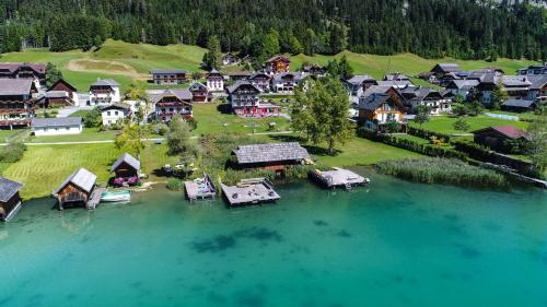 z góry widok na wioskę w środku jeziora w obiekcie See Hotel Kärntnerhof- das Seehotel am Weissensee! w mieście Weissensee