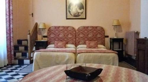 a hotel room with two beds and a table at Hotel Ordóñez Sandoval in Úbeda