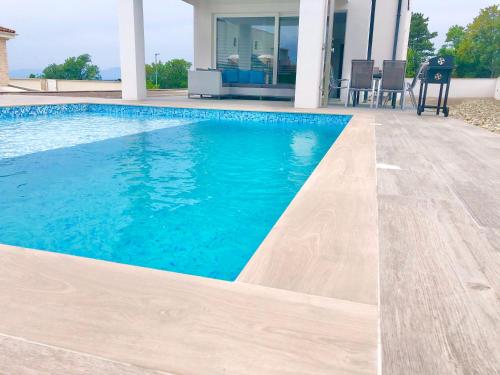 a swimming pool with blue water in a house at SPA House in Crikvenica