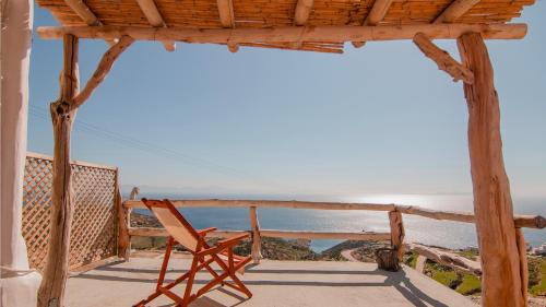 a chair sitting on a porch looking out at the ocean at Dimitrakis Guesthouse in Donoussa