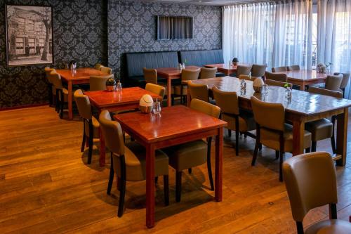 a dining room with wooden tables and chairs at `t Wapen van Terschelling in Midsland