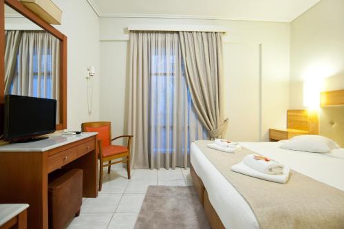a hotel room with two beds and a television at Fedriades Delphi Hotel in Delfoi