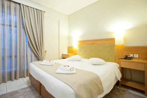 a hotel room with two beds and a window at Fedriades Delphi Hotel in Delfoi