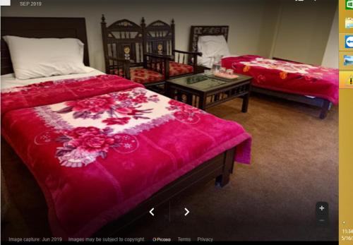 a living room with two beds and a table at Motel 35 in Alīābād