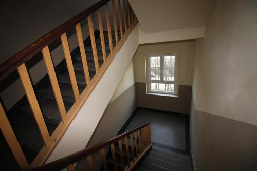 um corredor vazio com uma escada e uma janela em Ali 2 em Sosnowiec