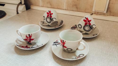 a group of cups and saucers on a table at Apartman Davidović in Valjevo