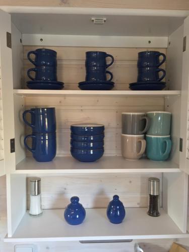 a shelf filled with blue bowls and cups at Tinyhouse Bamberg in Pettstadt