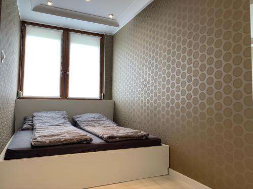 a bed in a room with a window at Ruben Apartman City Center in Debrecen