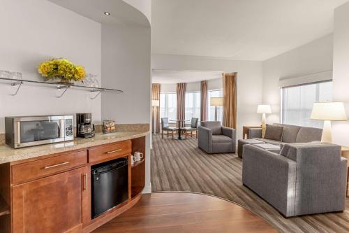 a living room with a couch and a kitchen with a microwave at Hyatt House Richmond - Short Pump in Richmond