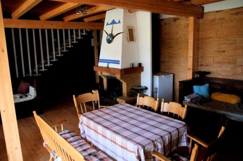 a room with a table and chairs and a fireplace at Old Fane's Lodge in Măraşu
