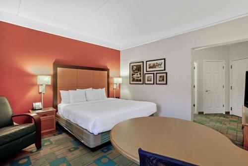 a hotel room with a bed and a table at La Quinta by Wyndham Winston-Salem in Winston-Salem