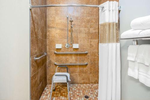 a shower with a chair in a bathroom at La Quinta by Wyndham Glen Rose in Glen Rose