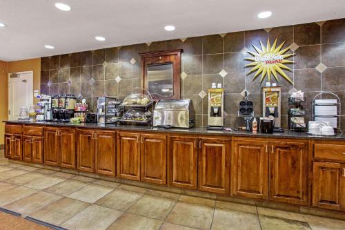 a kitchen with wooden cabinets and a counter at La Quinta by Wyndham Bismarck in Bismarck