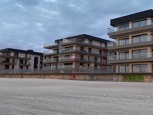 un edificio con balcones al costado de una calle en Apartament IDEAL, en Dziwnów