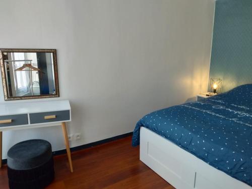 a bedroom with a bed and a mirror and a stool at Le Gambetta in Poitiers