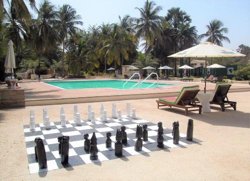 a chess board in front of a swimming pool at Kololi Beach Resort in Kololi
