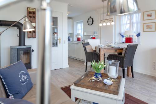 een woonkamer met een tafel en een keuken bij Watthüs in Morsum