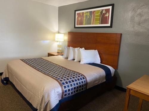 um quarto de hotel com uma cama grande com almofadas brancas em Usa Inn em Mount Vernon