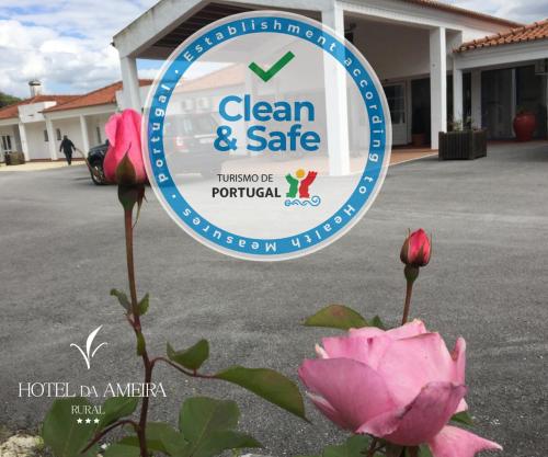 a sign with a pink rose in front of a building at Hotel Rural da Ameira in Montemor-o-Novo