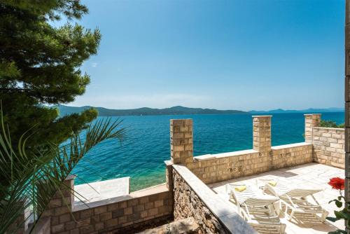 a patio with chairs and a view of the ocean at Beach Villa Ratac in Slano