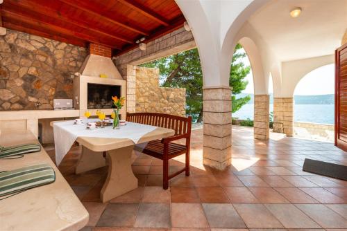 an outdoor dining room with a table and a fireplace at Beach Villa Ratac in Slano