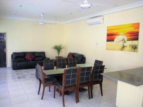 a living room with a table and chairs and a couch at Kololi Beach Resort in Kololi