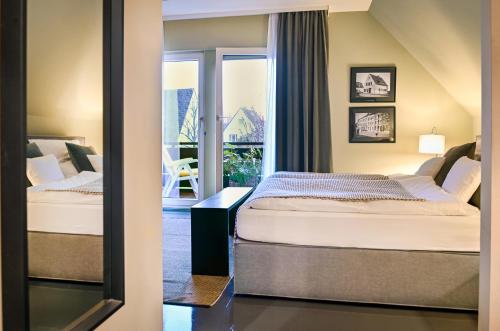 2 Betten in einem Hotelzimmer mit Fenster in der Unterkunft Messeapartment Sunny Side in Düsseldorf