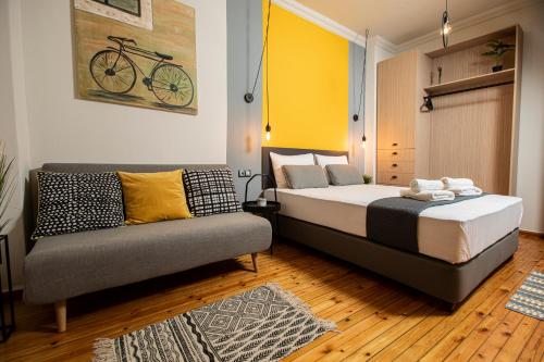 een slaapkamer met een bed en een bank bij Thess Quality Urban Living in Thessaloniki