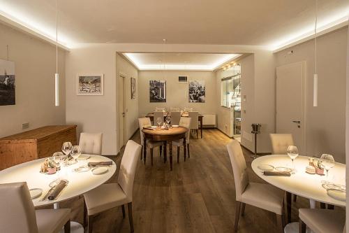 een eetkamer met witte tafels en witte stoelen bij L'Orangerie in Cortona