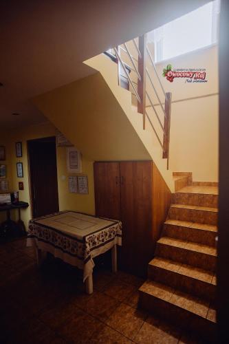 a room with a staircase with a table and a stair case at Owocowy Raj Nad Zalewem in Modła Królewska