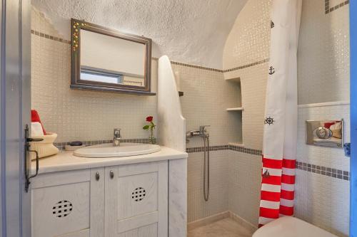 a bathroom with a sink and a shower at Lava Oia's in Oia