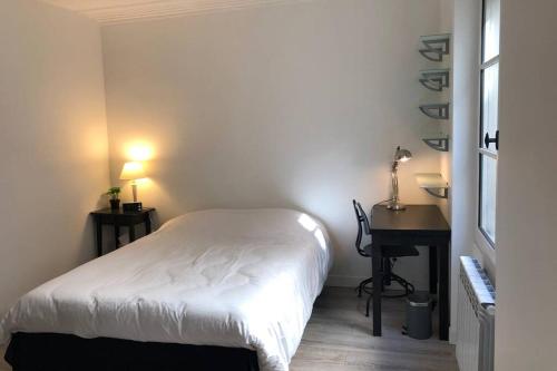 ein kleines Schlafzimmer mit einem Bett und einem Schreibtisch in der Unterkunft Appartement de charme à Montmartre in Paris