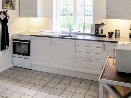 a kitchen with white cabinets and a sink and a window at Historic Water Tower Retreat-By Traum in Dannemare
