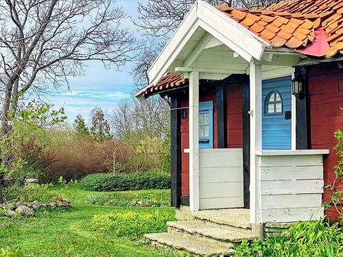 ein kleines rotes und blaues Haus mit einer Veranda in der Unterkunft 4 person holiday home in L TTORP in Löttorp