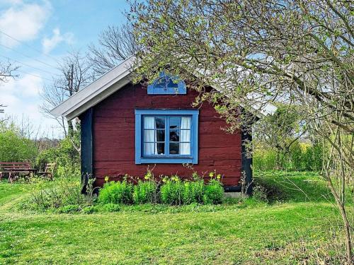 een klein rood huis met een raam in een veld bij 4 person holiday home in L TTORP in Löttorp