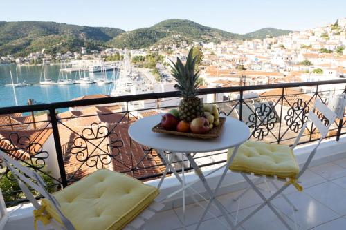 a table with a pineapple and fruit on a balcony at Gigi Rooms in Poros