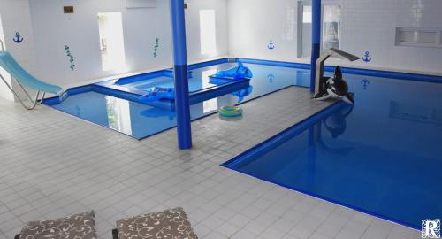 a room with a swimming pool with a sink at Hotel Rustikal in Horní Cerekev