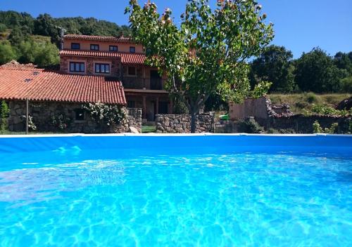 una casa con una gran piscina frente a ella en Casa Rural La Tablilla y La Terraza en Navalperal de Tormes